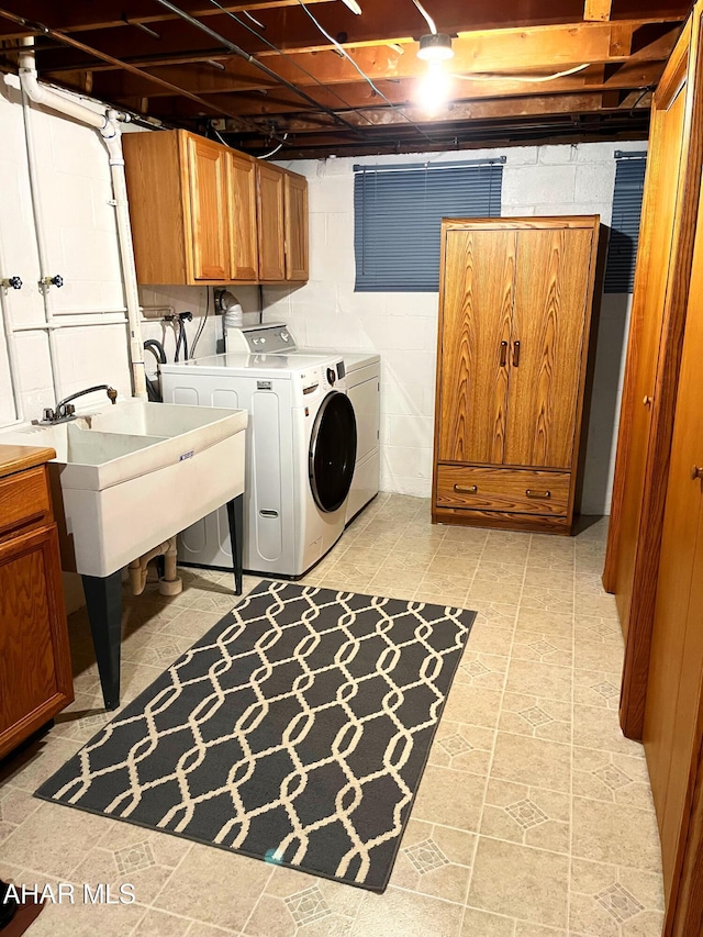 clothes washing area with cabinets, separate washer and dryer, and sink