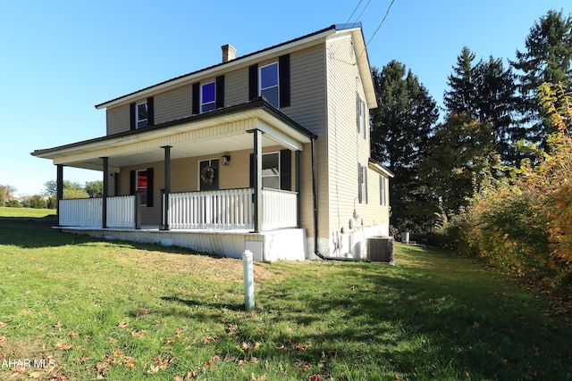 view of front of house with a porch, central AC, and a front lawn