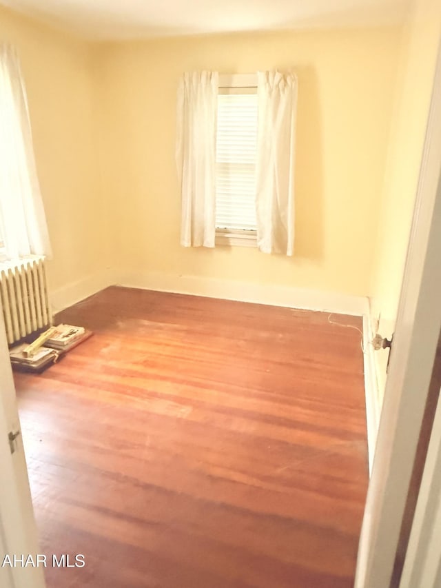 414 27th Ave, Altoona, PA 16601 - spare room featuring radiator heating unit, wood finished floors, and baseboards