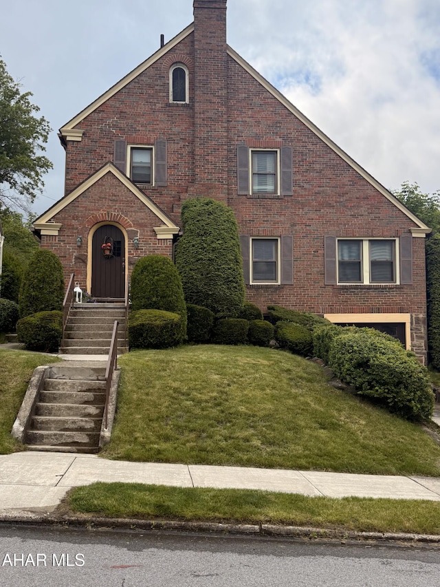 414 27th Ave, Altoona, PA 16601 - traditional-style house featuring brick siding, a front yard, and a chimney