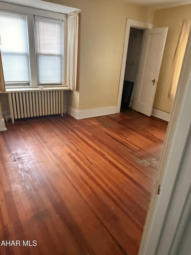 414 27th Ave, Altoona, PA 16601 - empty room with radiator, wood finished floors, and baseboards
