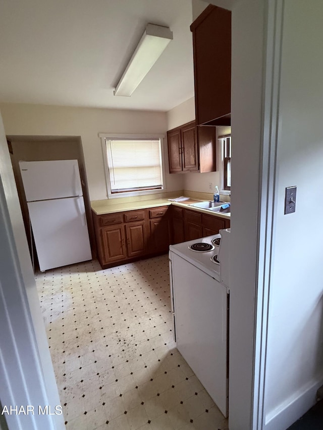 414 27th Ave, Altoona, PA 16601 - kitchen with white appliances, a sink, light countertops, light flooring, and brown cabinetry