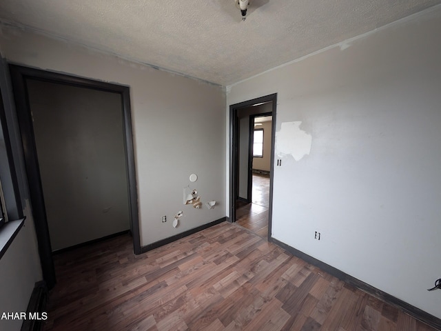 unfurnished bedroom featuring dark wood-type flooring and a textured ceiling