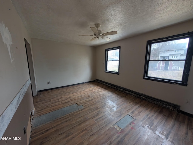 unfurnished room with hardwood / wood-style flooring, ceiling fan, and a textured ceiling