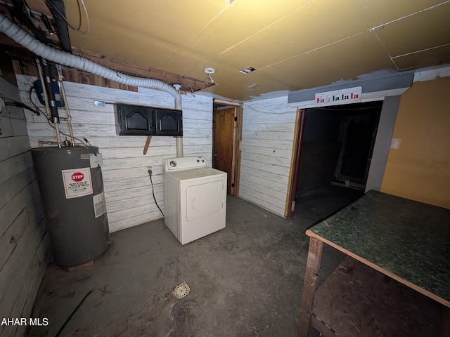 basement featuring wooden walls, washer / clothes dryer, and electric water heater