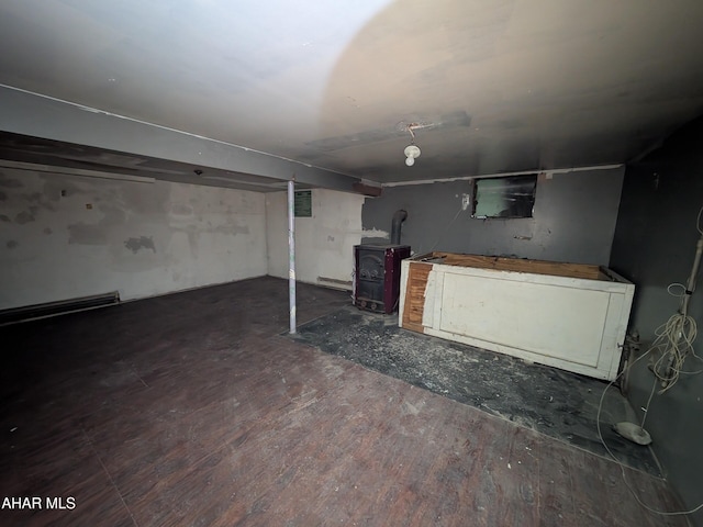 basement featuring hardwood / wood-style floors and a wood stove