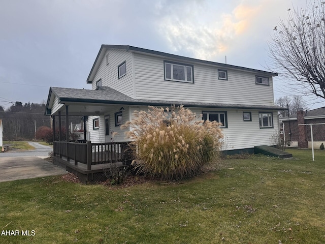 back of property featuring a yard and a wooden deck