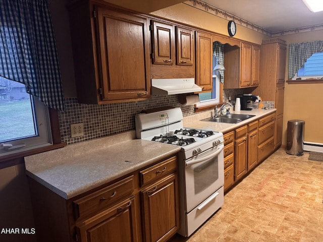 kitchen featuring backsplash, white gas stove, sink, and a baseboard radiator