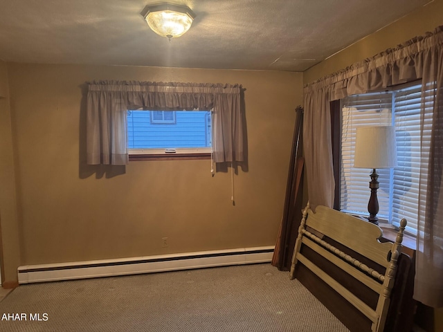 unfurnished bedroom featuring carpet flooring, a textured ceiling, and a baseboard heating unit