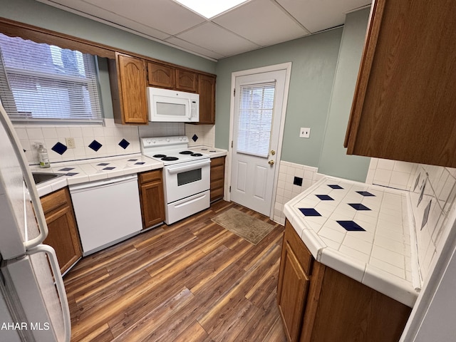 2123 2nd Ave, Altoona, PA 16602 - kitchen featuring tile counters, brown cabinetry, decorative backsplash, white appliances, and dark wood-type flooring