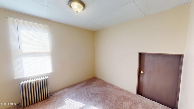 carpeted empty room with radiator heating unit