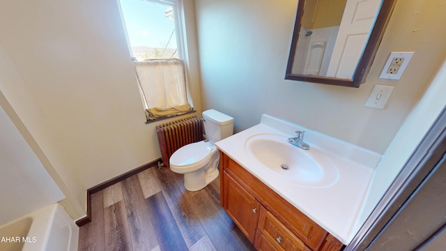 bathroom featuring toilet, wood finished floors, radiator, baseboards, and vanity