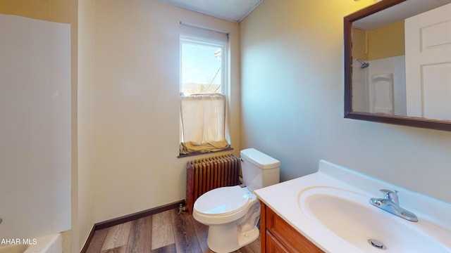 full bath featuring toilet, wood finished floors, radiator heating unit, walk in shower, and vanity