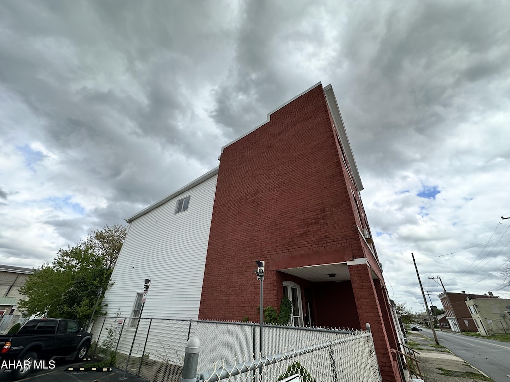 view of side of property with fence and uncovered parking