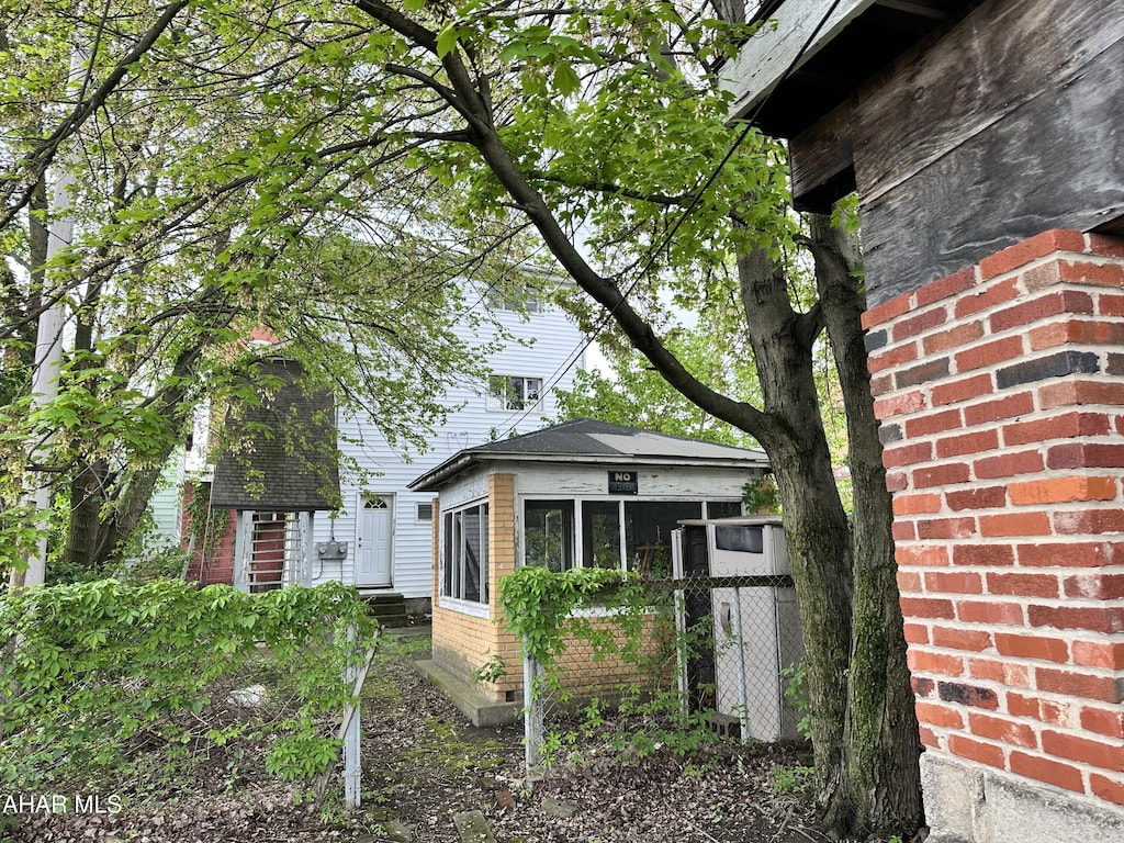 view of side of property with fence and brick siding