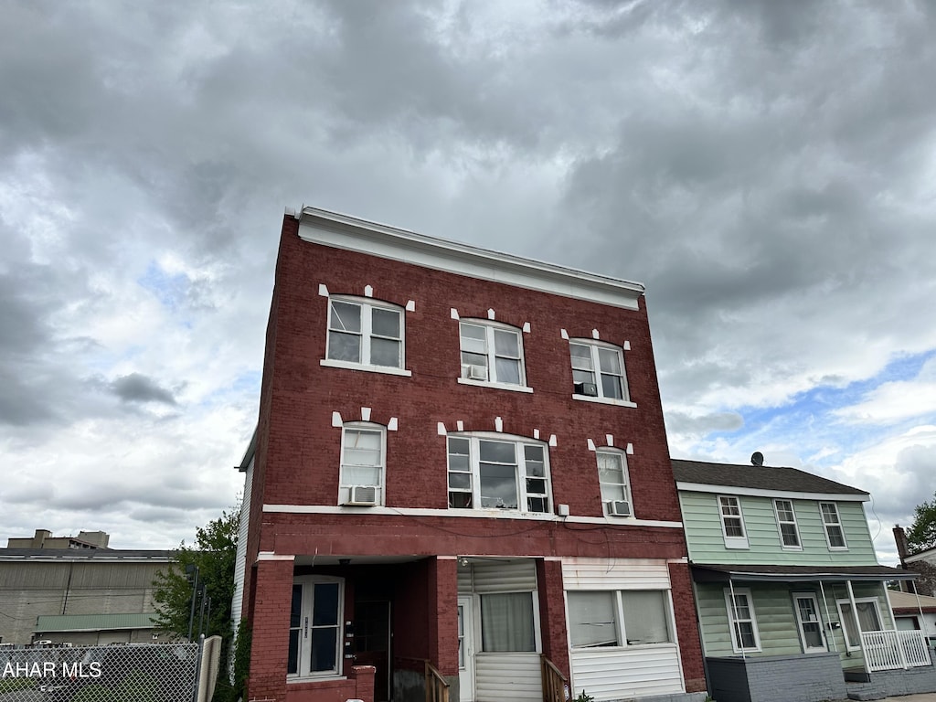 view of building exterior featuring cooling unit and fence