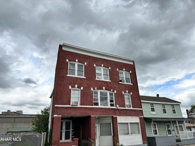 view of building exterior featuring cooling unit and fence