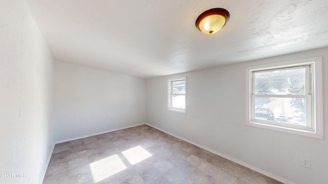 unfurnished room with baseboards