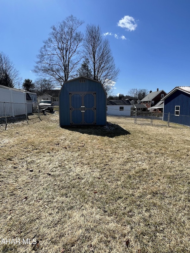 view of yard with an outbuilding, a storage shed, and fence