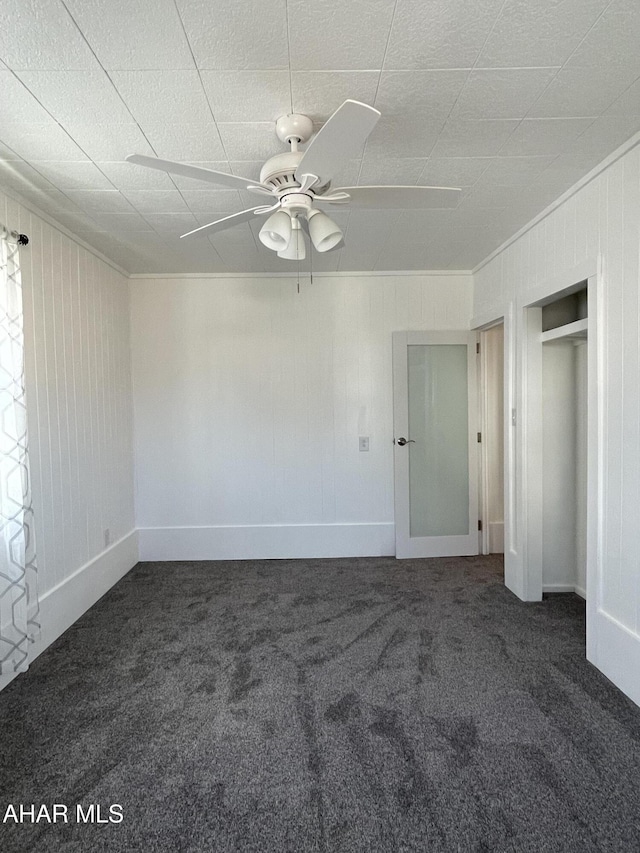 unfurnished bedroom featuring crown molding, a closet, carpet floors, and ceiling fan