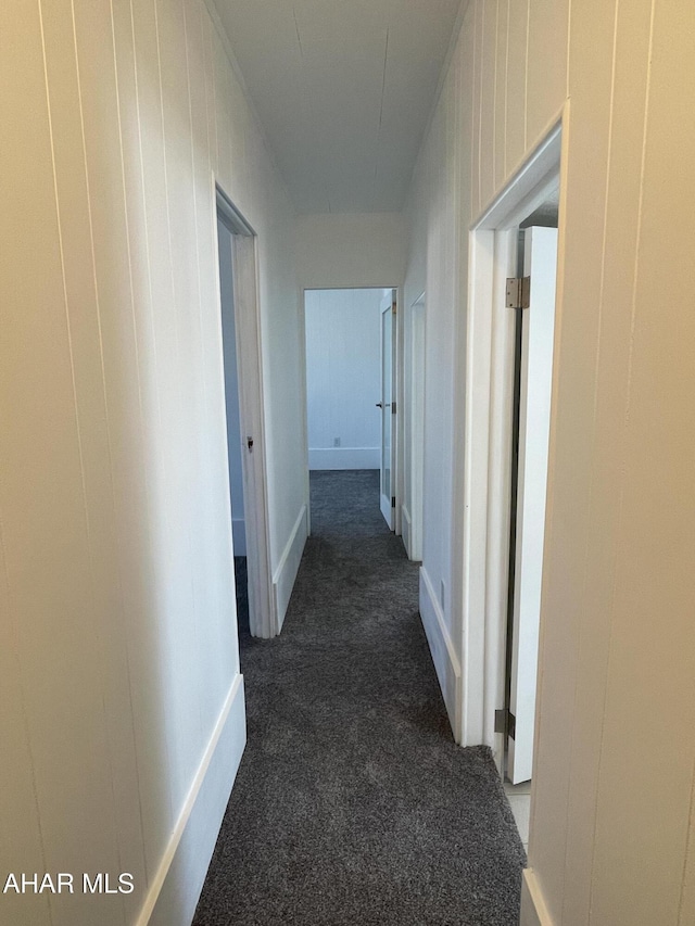 hallway featuring dark colored carpet