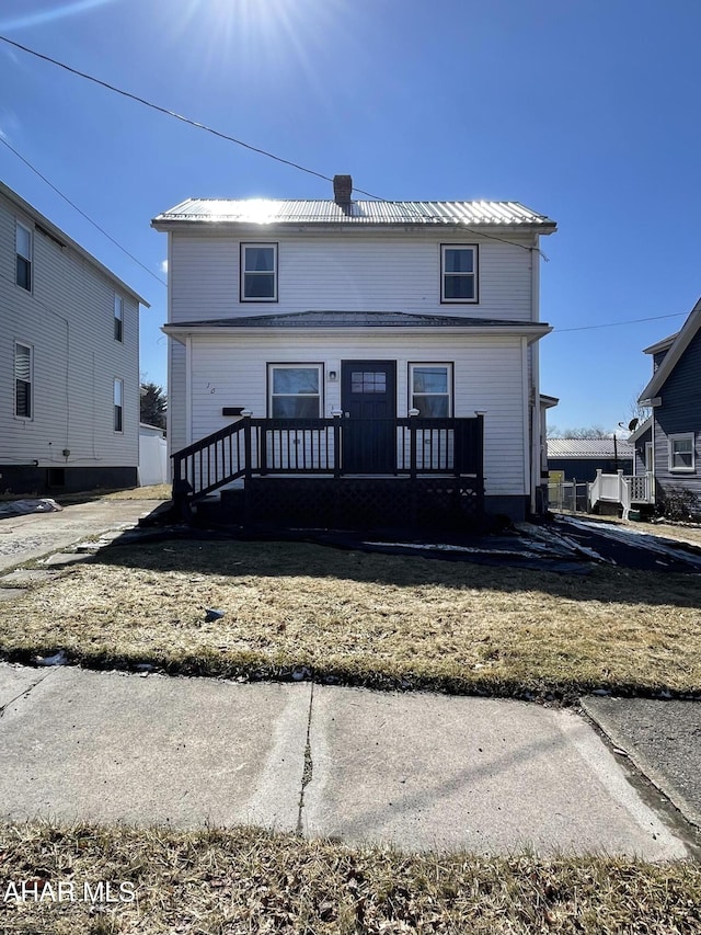 rear view of property with metal roof and a chimney