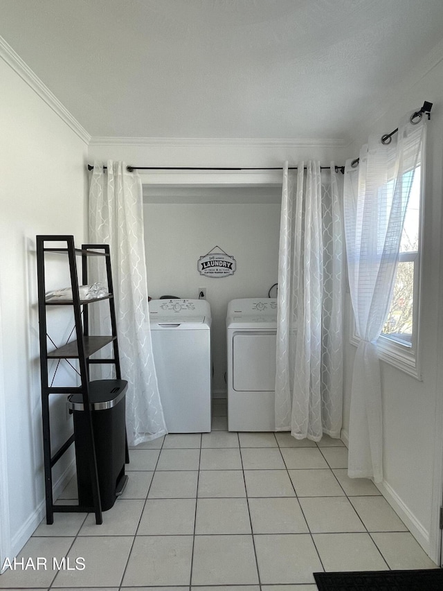 laundry room featuring light tile patterned floors, baseboards, laundry area, crown molding, and washer and clothes dryer