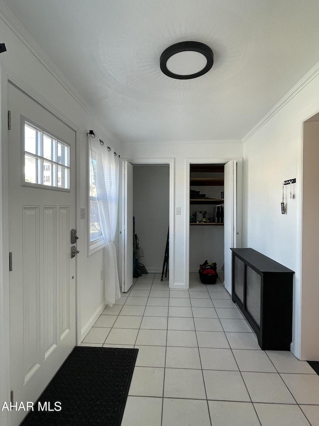 entrance foyer featuring crown molding and light tile patterned floors