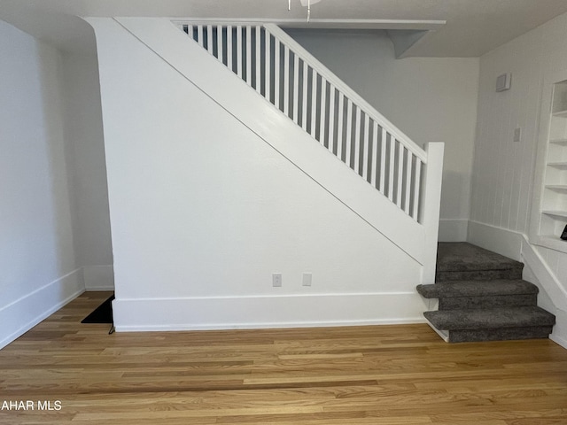 stairs with baseboards and wood finished floors