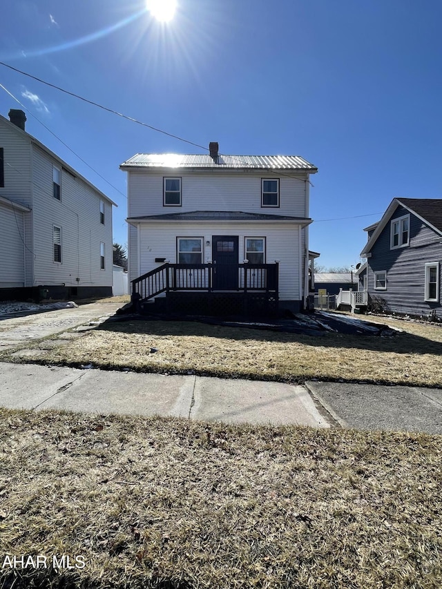 back of property featuring metal roof and a chimney