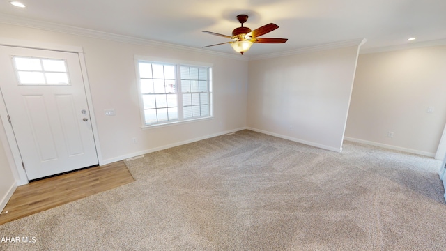 entryway featuring crown molding, a healthy amount of sunlight, light carpet, and ceiling fan