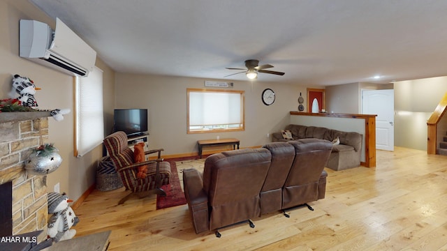 living room featuring light wood-type flooring, a wall unit AC, and ceiling fan