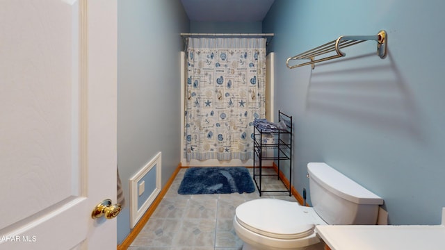 bathroom featuring a shower with shower curtain and toilet