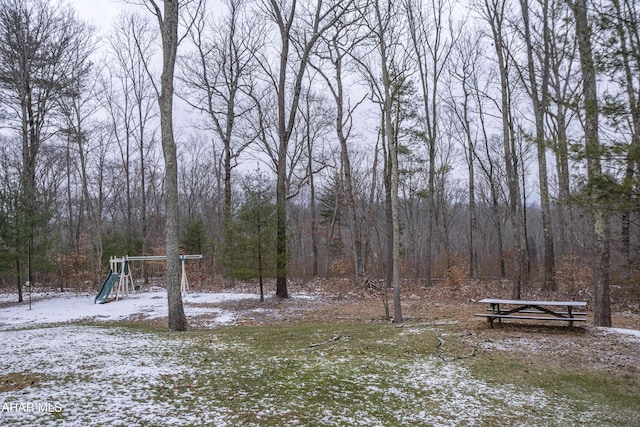 yard covered in snow with a playground