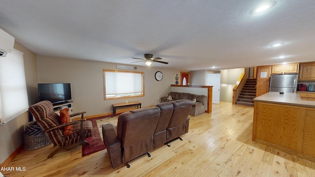 living room with ceiling fan and light hardwood / wood-style flooring