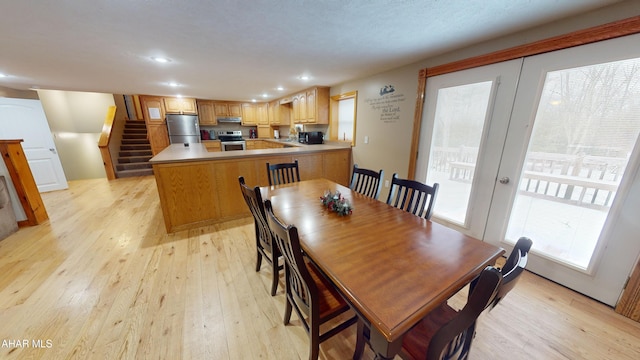 dining room with french doors and light hardwood / wood-style floors