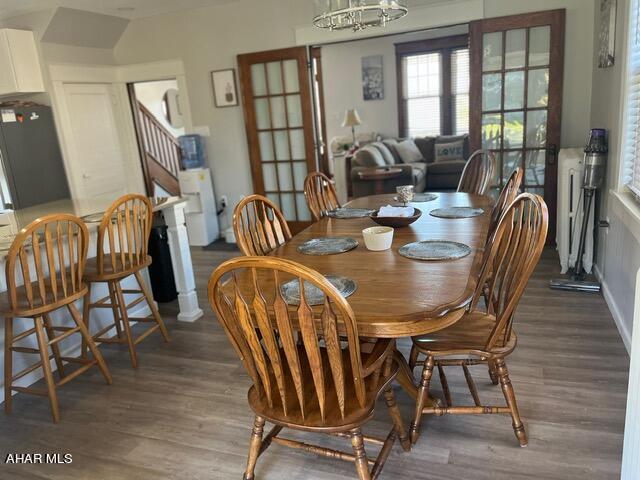 dining space featuring dark hardwood / wood-style floors and an inviting chandelier