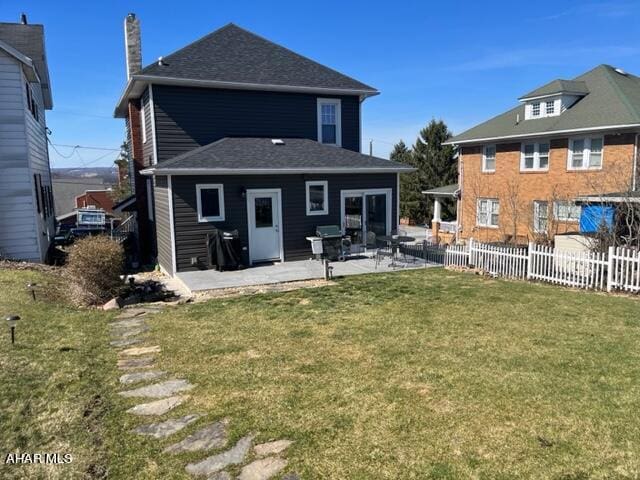 rear view of house featuring a patio area and a yard