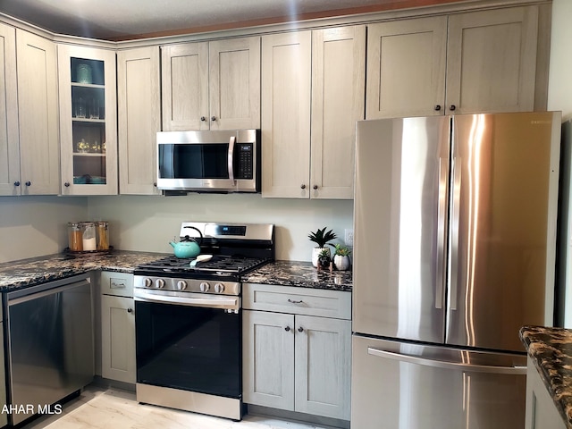 kitchen with dark stone counters and stainless steel appliances