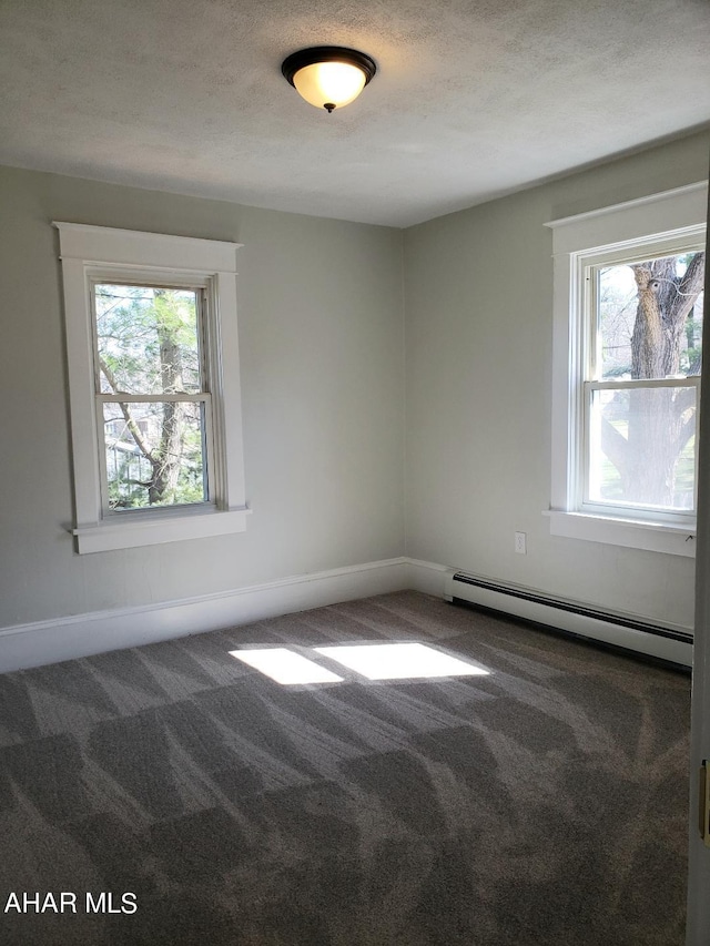 empty room with a textured ceiling, carpet floors, and baseboard heating