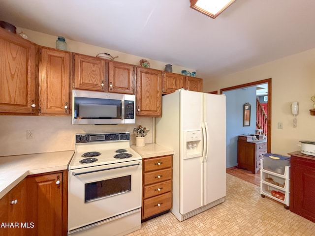 6334 Black Valley Rd, Everett, PA 15537 - kitchen with light floors, white appliances, light countertops, and brown cabinetry