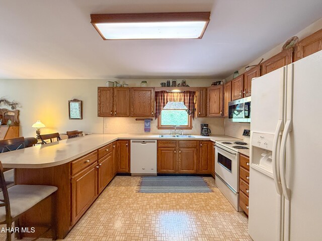 6334 Black Valley Rd, Everett, PA 15537 - kitchen featuring white appliances, brown cabinetry, light countertops, a sink, and a peninsula