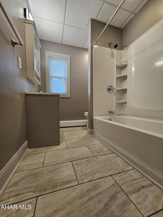 bathroom with a paneled ceiling, toilet, shower / bath combination, and baseboard heating