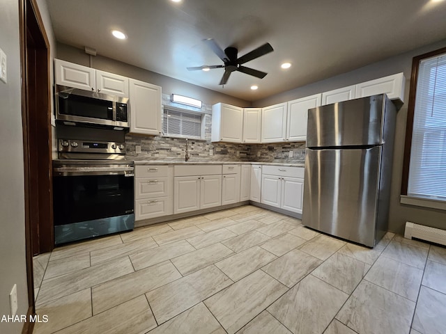 kitchen featuring tasteful backsplash, white cabinetry, and appliances with stainless steel finishes