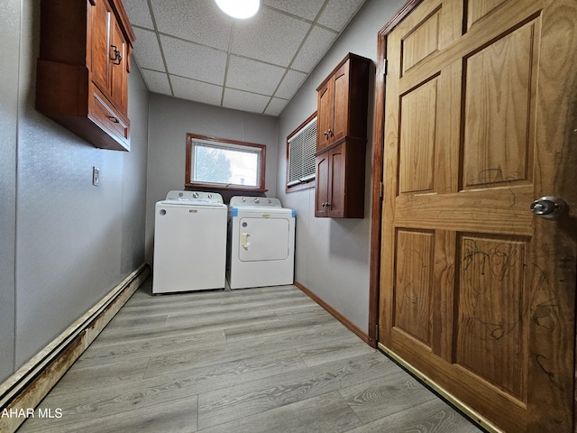 laundry room featuring cabinets, independent washer and dryer, light hardwood / wood-style floors, and baseboard heating