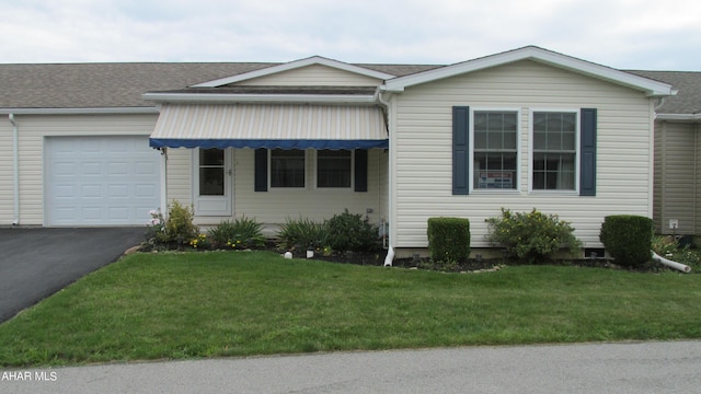 ranch-style house with a garage and a front lawn