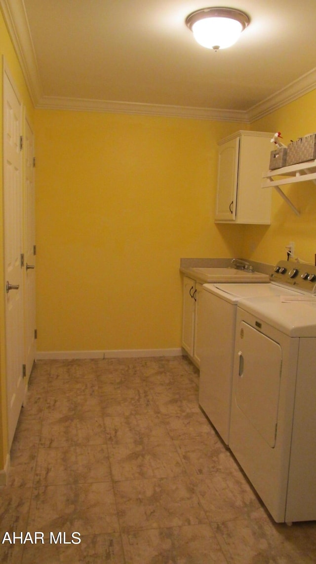 laundry area with cabinets, washing machine and dryer, and crown molding