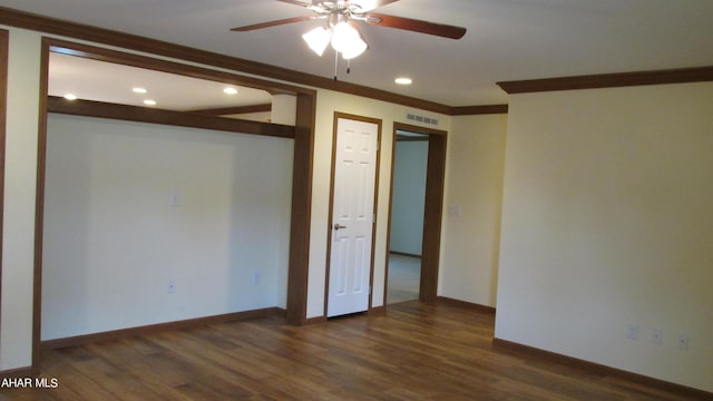 empty room with ceiling fan, dark hardwood / wood-style flooring, and ornamental molding