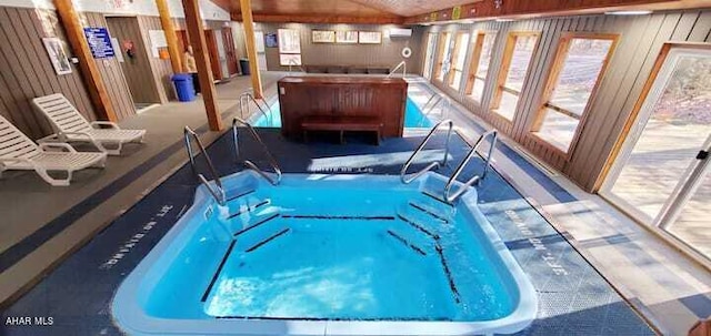 view of swimming pool featuring a wall unit AC and a hot tub