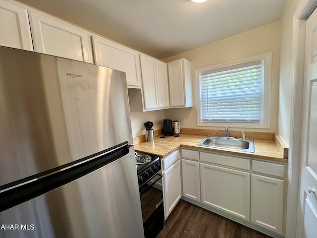 kitchen with stainless steel fridge, dark wood-type flooring, sink, white cabinets, and black range with electric stovetop